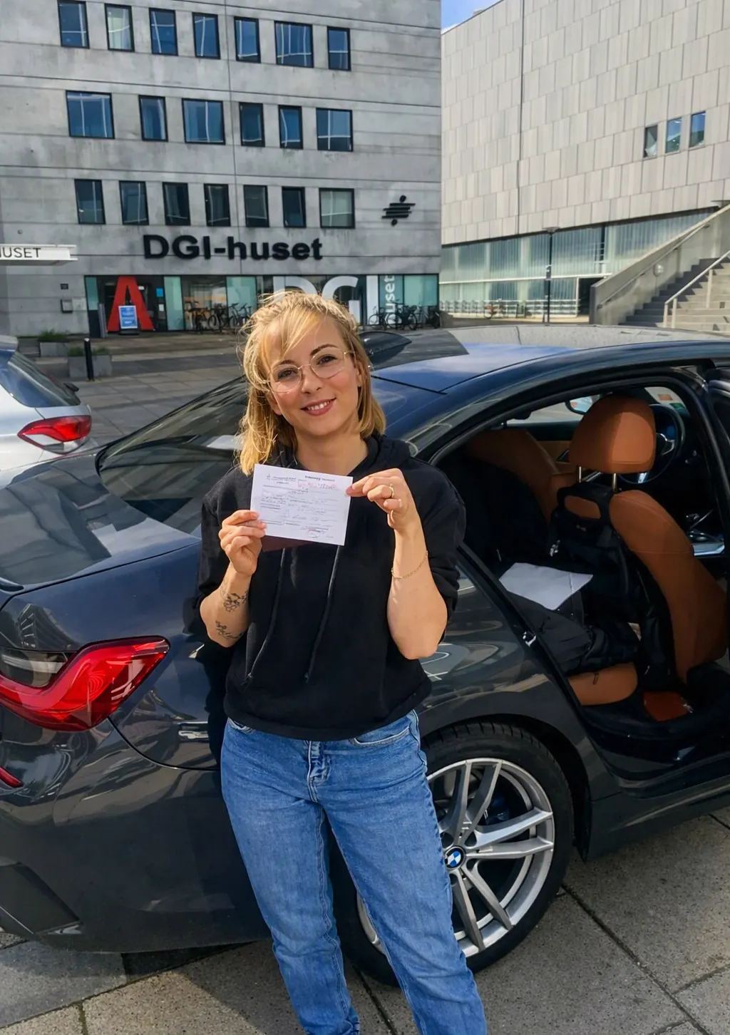Glad elev med bestået køreprøve foran DGI-huset i Aarhus